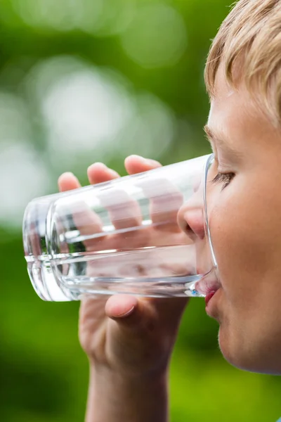 Boy drinking fresh water from glass Stock Image