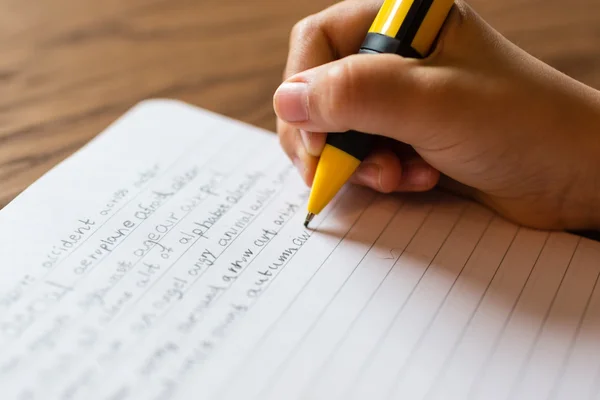 Mädchen schreibt von Hand auf Notizblock — Stockfoto