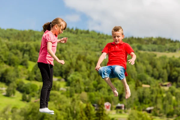 Kids jumping on bouncy pillow — Stock Photo, Image