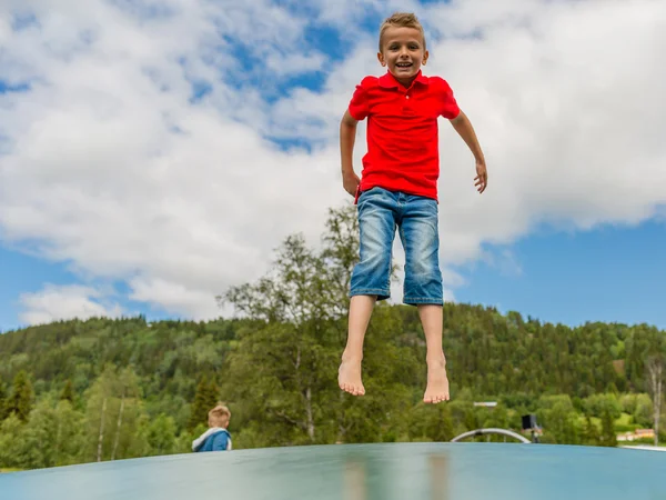 Giovane ragazzo che salta sul trampolino — Foto Stock