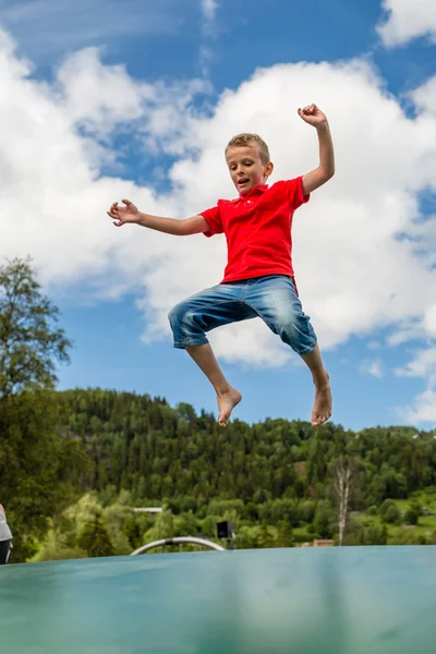 Young boy jumping on trampoline — Stock Photo, Image