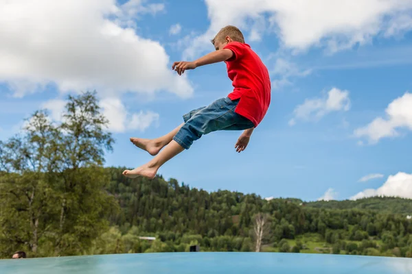 Young boy jumping on trampoline — Stock Photo, Image