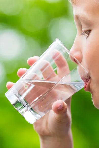 Мальчик пьет свежую воду из стекла — стоковое фото