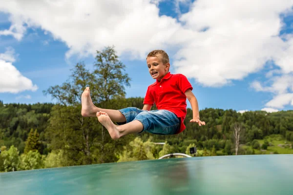 Young boy jumping on trampoline — Stock Photo, Image