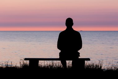 Silhouette of man on bench clipart