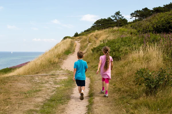 Kinderen lopen langs de kust — Stockfoto