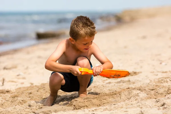 Giovane ragazzo con pala di plastica — Foto Stock