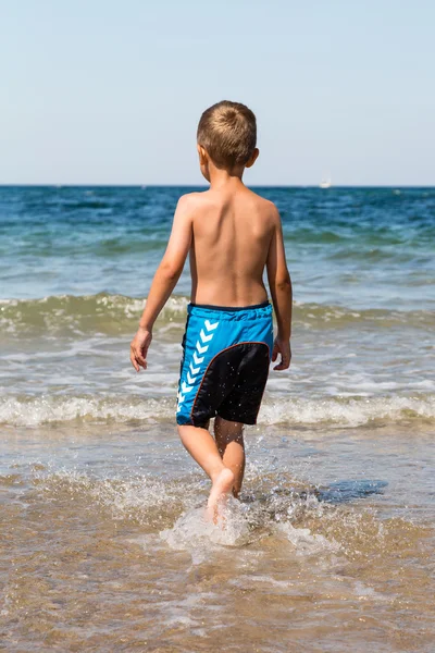 Junge spielt im Ozean — Stockfoto