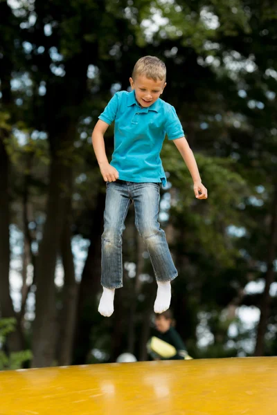 Jongen op geel stuiteren kussen — Stockfoto