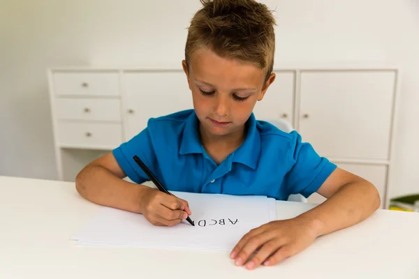 Pojken skriver abc alfabetet — Stockfoto
