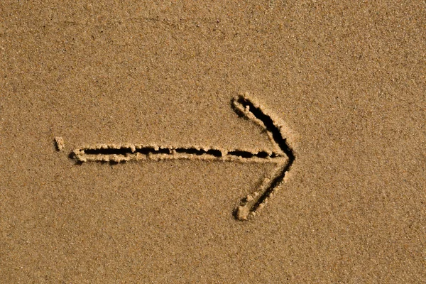 Flèche dessinée dans le sable — Photo