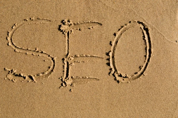 The word SEO written in the sand — Stock Photo, Image