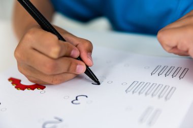 Çocuk ödevini yapıyor.