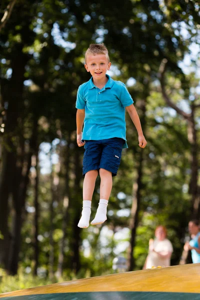 Dreng har det sjovt på legepladsen - Stock-foto