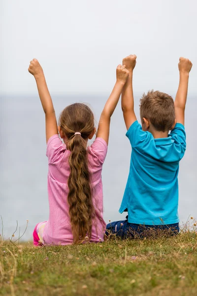 Niños con los brazos levantados —  Fotos de Stock