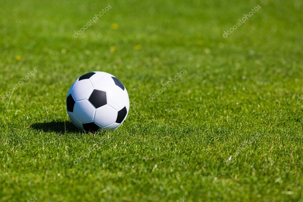 Green pitch with soccer ball Stock Photo by ©Bigandt 58907215