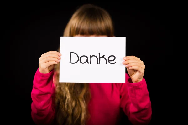 Dziecko trzyma znak z niemieckiego słowa Danke - dziękuję — Zdjęcie stockowe