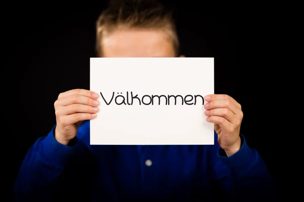 Child holding sign with Swedish word Valkommen - Welcome — Stock Photo, Image