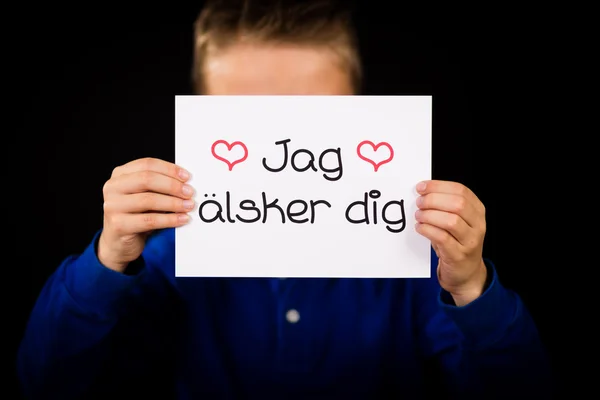 Dziecko trzyma znak ze szwedzkim słowa Jag Alsker Dig - I Love Yo — Zdjęcie stockowe