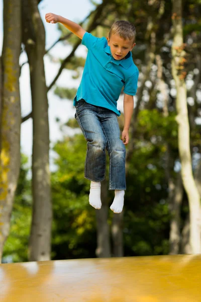 Junge auf gelbem Sprungkissen — Stockfoto