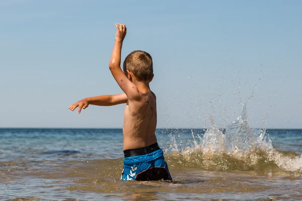 Menino brincando no oceano — Fotografia de Stock