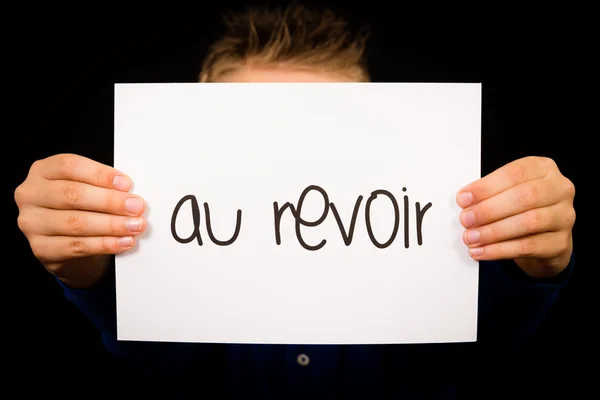 Child holding sign with French word Au Revoir - Goodbye — Stock Photo, Image