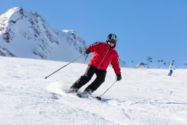 Kayakçı yamaçta kayak yapıyor.