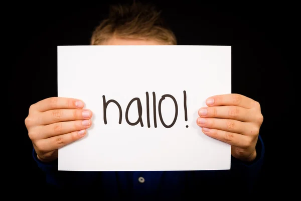 Kind hält Schild mit deutschem Wort hallo - hallo auf englisch — Stockfoto