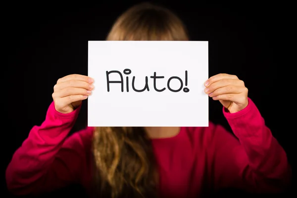 Child holding sign with Italian word Aiuto - Help — Stock Photo, Image