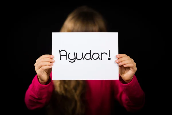 Child holding sign with Spanish word Ayudar - Help — Stock Photo, Image