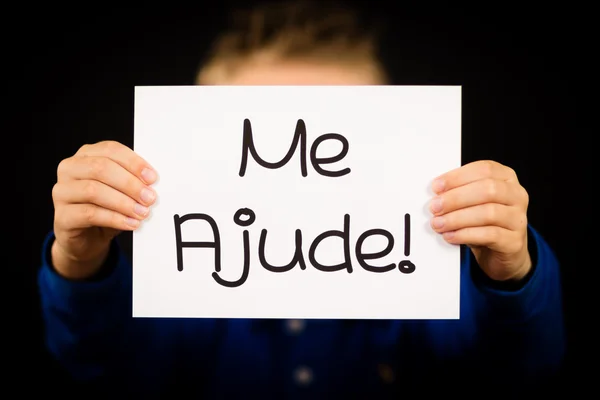 Child holding sign with Portuguese words Me Ajude - Help Me — Stock Photo, Image