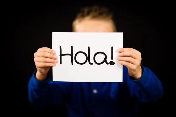 Ребенок держит табличку с испанским словом Hola - Hello — стоковое фото