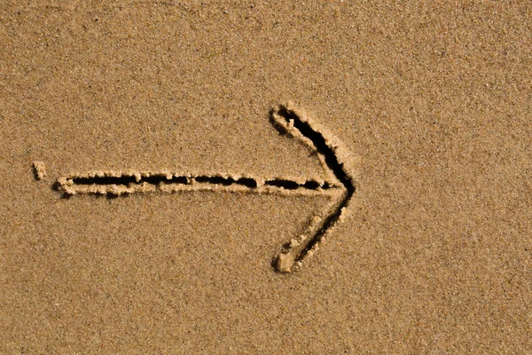 Flèche dessinée dans le sable — Photo