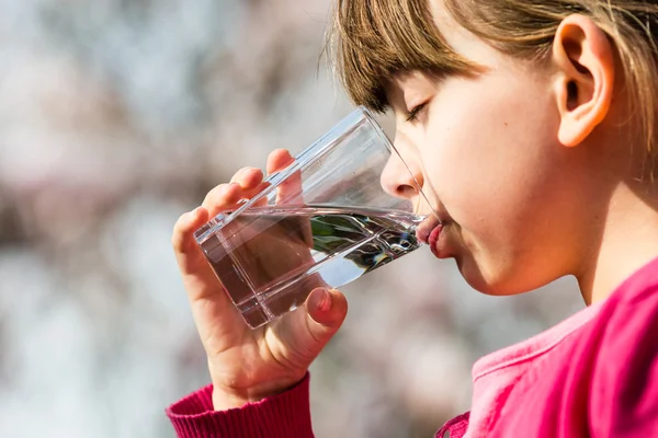 Ragazza che beve acqua dal vetro — Foto Stock