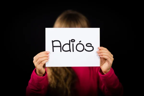Child holding sign with Spanish word Adios - Goodbye — Stock Photo, Image