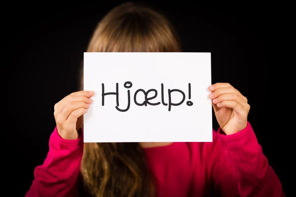 Barn med skylt med danska ordet Hjaelp - hjälp — Stockfoto
