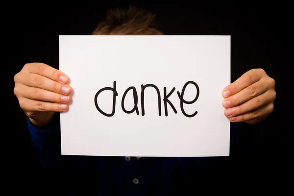 Dziecko trzyma znak z niemieckiego słowa Danke - dziękuję — Zdjęcie stockowe
