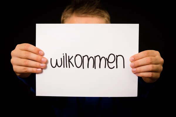 Anak memegang tanda dengan kata Jerman Wilkommen Selamat datang — Stok Foto