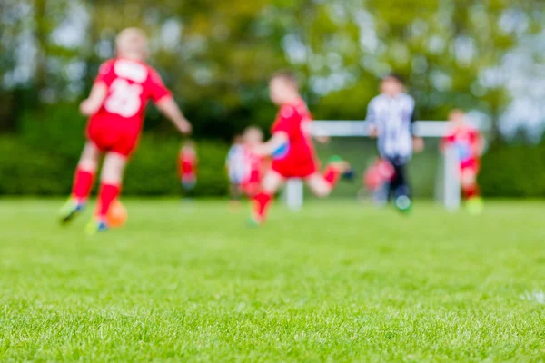 Niños borrosos jugando partido de fútbol juvenil — Foto de Stock