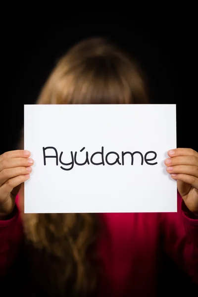 Мені допомогти дитині холдингу знак з іспанське слово Ayudame- — стокове фото