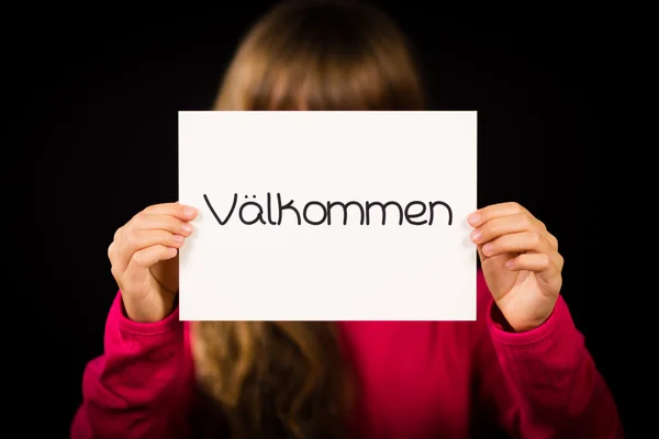Child holding sign with Swedish word Valkommen - Welcome — Stock Photo, Image