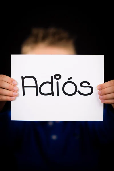 Child holding sign with Spanish word Adios - Goodbye — Stock Photo, Image