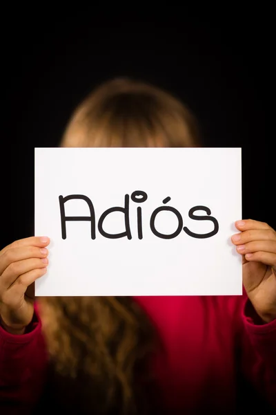 Child holding sign with Spanish word Adios - Goodbye — Stock Photo, Image