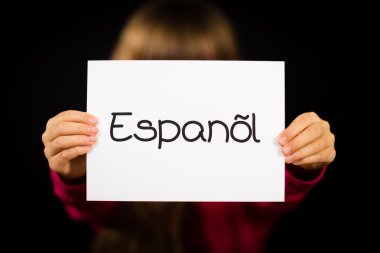 Child holding sign with Spanish word Espanol - Spanish in Englis clipart