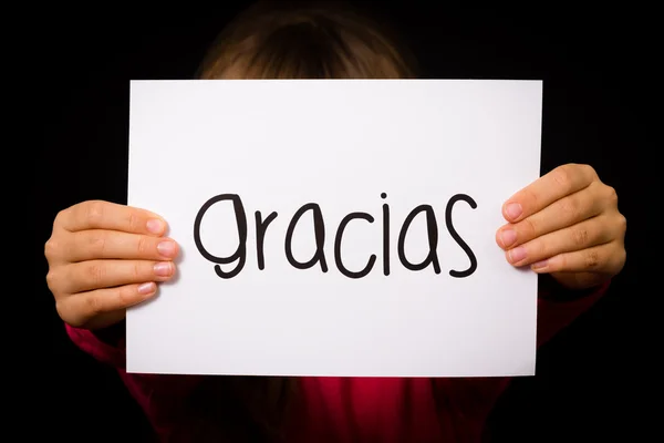 Kind hält Schild mit spanischem Wort gracias - danke — Stockfoto