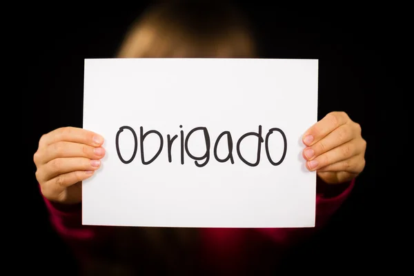 Child holding sign with Portuguese word Obrigado - Thank You — Stock Photo, Image