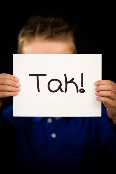 Criança segurando sinal com palavra dinamarquesa Tak - Obrigado — Fotografia de Stock