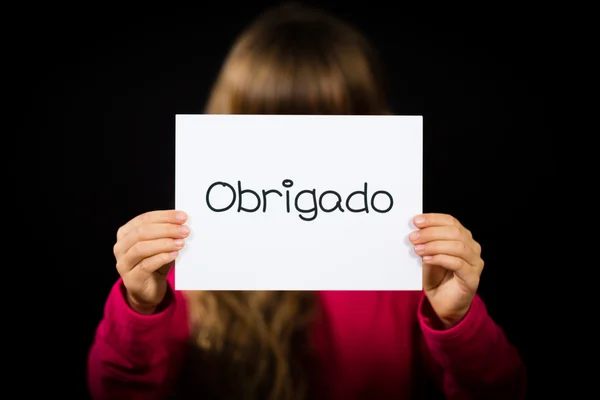 Child holding sign with Portuguese word Obrigado - Thank You — Stock Photo, Image