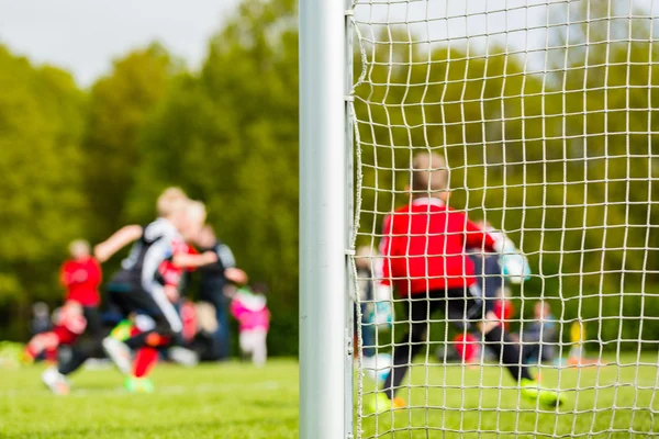 Crianças desfocadas jogando jogo de futebol juvenil — Fotografia de Stock