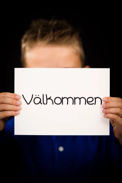 Child holding sign with Swedish word Valkommen - Welcome — Stock Photo, Image